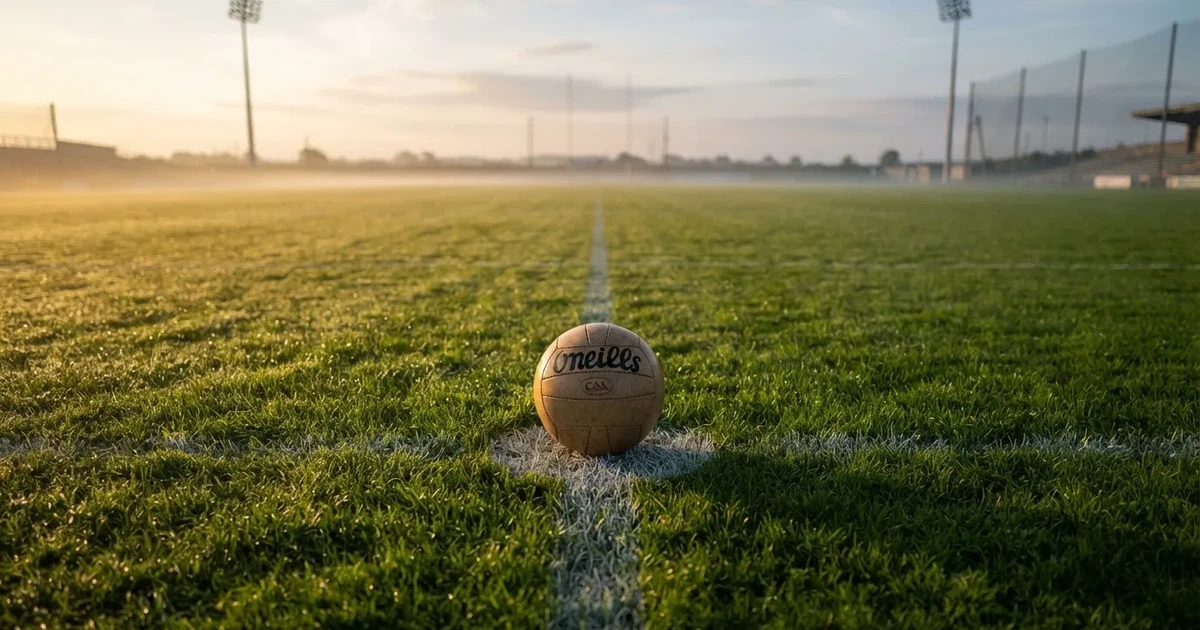 A ball on the centre spot of a grass pitch in morning light
